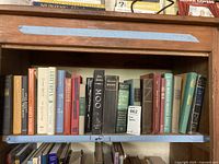 Books on a wooden shelf showing a variety of titles including Sherlock Holmes and Worlds Great Classics.