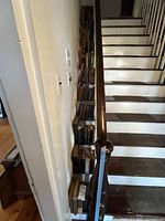 Books stacked along stair steps in a narrow stairwell, showing overall lot size and setting.