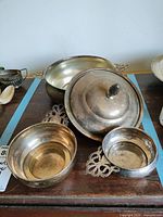 Overview of three bowls and lid arranged on wood surface