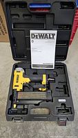 DeWalt pin nailer, case, and manual arranged in carrying case showing top view