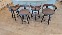 Four stools aligned in kitchen facing camera