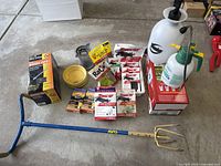 Full overview of lot including sprayers, bird spikes, mouse traps, mosquito refills, Garden Claw tool, and drip trays.