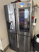 Front view of stainless steel four-door refrigerator in garage