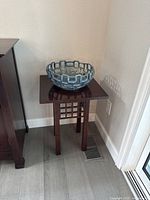 Side angle view of Stickley side table with blue decorative bowl on top, showing table height and wood finish.
