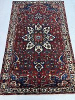 Full view of red-field rug with central medallion and border.
