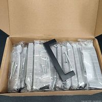 Box containing 30 individually wrapped black steel cabinet handles with screws.