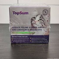 Front and side view of sealed TopSum calming pheromone diffuser refill 4-pack box showing product name, usage instructions, and branding with cat image.