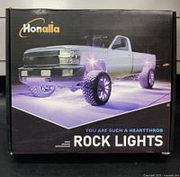 Box with Honalia brand and photo of a pickup truck showing purple underglow lights, labeling the product as rock lights.