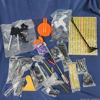 Full layout of dent removal tools including orange suction cups, metal puller tools, and various pads on blue backdrop.