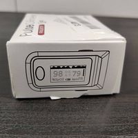 Side view of pulse oximeter box showing illustration of the device with an OLED display reflecting SpO2, pulse rate, and pulse index readings.