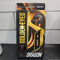 Box packaging of Red Dragon Golden Eyes darts, indicating 85% tungsten, 32 grams, steel tip darts.