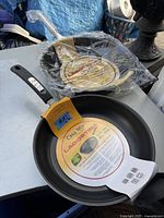 Two Lagostina non-stick frying pans: one Casa Mia 10 inch and one Capri 12 inch, shown together with labels and packaging.