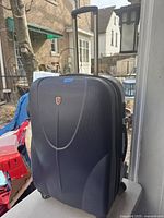 Front view of the large BBS suitcase showing main body and pull-up handle extended.