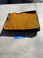 Photo of the closed antique photo album with a textured orange cover and inscription 'Stoughton Centennial 1921.'
