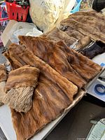 Images showing several large brown mink fur pieces with some creasing and age wear visible on leather sides and fur.