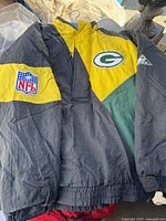 Front view of black, yellow, and green NFL winter pullover jacket with Green Bay Packers and NFL patches.