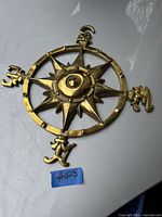 Photo showing the solid cast brass nautical compass wall hanging with detailed compass rose and cardinal direction markers.