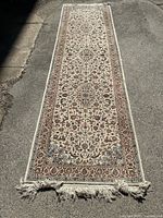 Full view of the Persian Tabriz runner rug laid out on the pavement showing overall length and pattern.