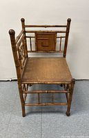 Front-angle view of the vintage bamboo corner chair showing bamboo construction and square panel on backrest.