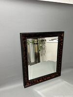 Front view of the rectangular wall hanging mirror showing the clear reflective surface and colorful decorative frame.