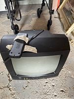 Front and top view of the Sanyo 14-inch CRT TV with remote taped to top, showing condition and controls