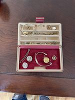 Top-down view of the jewelry box containing various jewelry pieces including earrings, bracelets, watch, rings, and pendants.