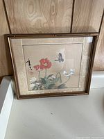 Front of framed artwork showing the Japanese style botanical print with butterfly and flowers, bamboo styled frame and textured mat.
