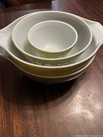 Stacked set of four green and white Pyrex bowls showing nesting sizes and pattern.