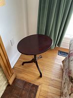 Side table positioned near wall and window, showing overall shape and height relative to the couch and fireplace.
