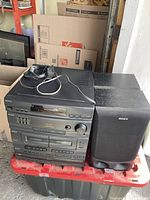 Photo showing full Sony stereo system stacked setup with wires on top and one of the speakers next to it