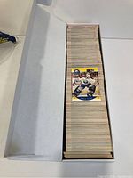 Top view of the long white protective box filled with hundreds of 1990 Pro Set hockey trading cards, one card displayed on top showing a hockey goalie player.