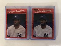 Front side of two 1990 Donruss Deion Sanders baseball cards featuring Deion Sanders in New York Yankees uniform, each in protective cases.