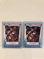 Front view of both Isiah Thomas 1989 Fleer All-Star basketball cards side by side inside clear protective sleeves, showing player image and card design.
