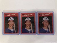 Three John Olerud rookie baseball cards shown front side wearing Toronto Blue Jays uniform, each in clear plastic protective cases.
