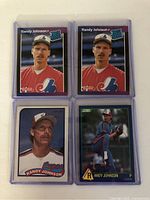 Four Randy Johnson baseball rookie cards shown front side in protective cases