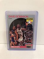 Front of 1990 NBA Hoops David Robinson rookie card showing action shot, team logo, and Rookie of the Year stamp in protective case.