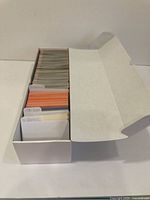 White card storage box with hundreds of assorted baseball cards inside, partially organized with labeled dividers for 1989 Donruss, 1992 Donruss, and 1990 Score cards.
