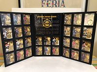 Full view of three-panel display showing 30 cards with embedded coins in black binder