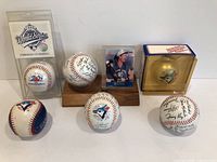 Full arrangement of five Toronto Blue Jays baseballs plus Pat Borders baseball card, showing condition and display cases
