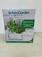 Front of AeroGarden Sprout kit box showing herbs growing and logo