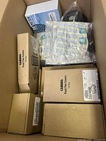 Wide shot showing multiple cardboard boxes labeled Cambro Food Pan Covers in various sizes and a sealed pack of disposable gloves in a box.