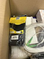 Photo showing Energizer battery charger and white cables inside a box