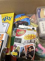 Photo of Seinfeld UNO card game, Hot Wheels car, and Guess Who? game in box