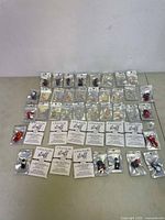 Full layout of lot with croc charms arranged in rows on left, and staff charm bracelets in original packaging on the right