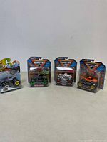 Four new Monster Jam mini trucks in original packaging displayed together.