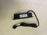 Side view of black mountable power strip showing power cord and metal mounting plate