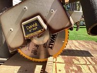 Close-up of DeWalt 10-inch saw blade with yellow teeth mounted on the radial arm saw.