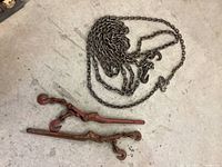 Photo showing two lever load binders and a coiled metal chain on the floor.