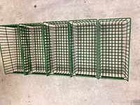 Five green heavy duty wire baskets stacked together, showing their rectangular shape and wire grid design.