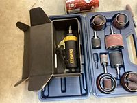 DeWalt air die grinder in a box placed inside blue molded carrying case with sanding drums and sleeves.